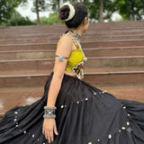 Indian model in Navratri chaniya choli wearing oxidized silver mirror work ghungroo cuff on raised wrist, Garba event background with fairy lights
