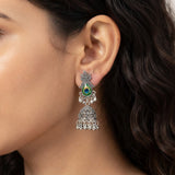 Close-up side profile of woman wearing oxidized silver peacock jhumka earrings