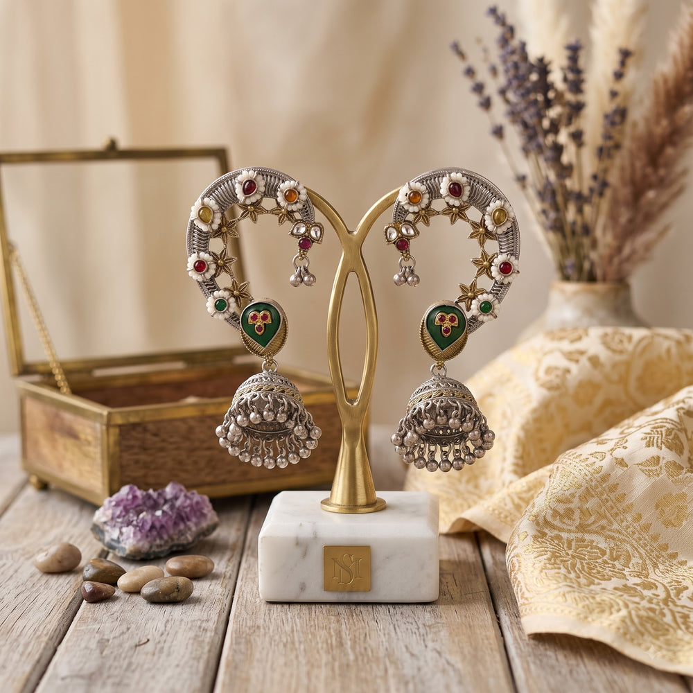 Pair of dual tone Navratna floral ear cuff jhumka earrings on gold earring stand with marble base, wooden jewellery box, amethyst crystal cluster, river pebbles, lavender stems and gold zari brocade dupatta in warm beige styled setting
