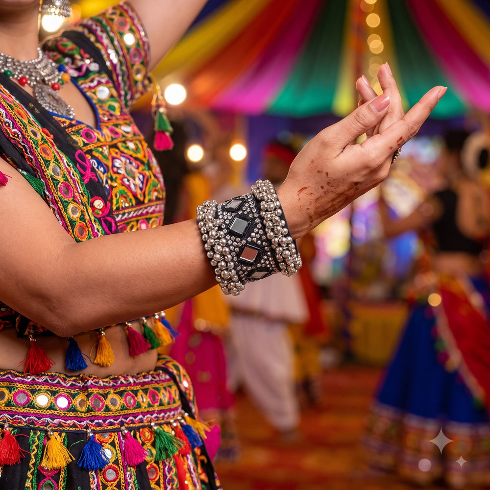 Indian model in multi-colour Navratri outfit wearing oxidized silver ghungroo cuff bracelet at Garba event, henna hands raised in dance pose