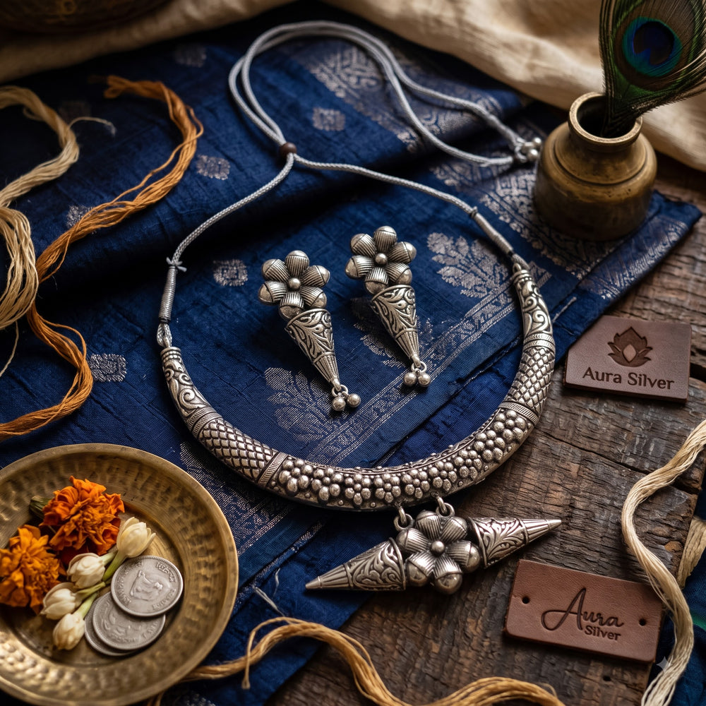 Hasli necklace and earrings set styled on teal silk with brass accents
