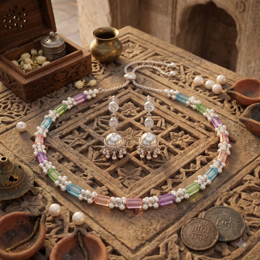 Pastel stone necklace and silver-tone jhumka earrings on marble