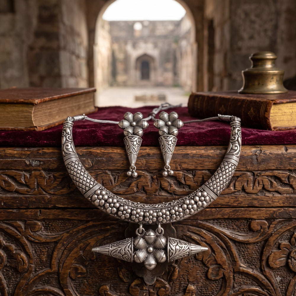 Hasli collar necklace with floral pendant and matching earrings styled on wood