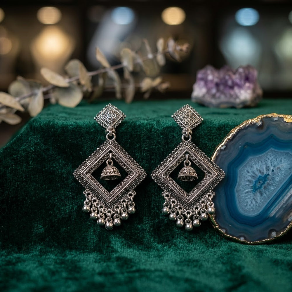 Oxidized silver diamond jhumka earrings on green velvet with agate stone aesthetic