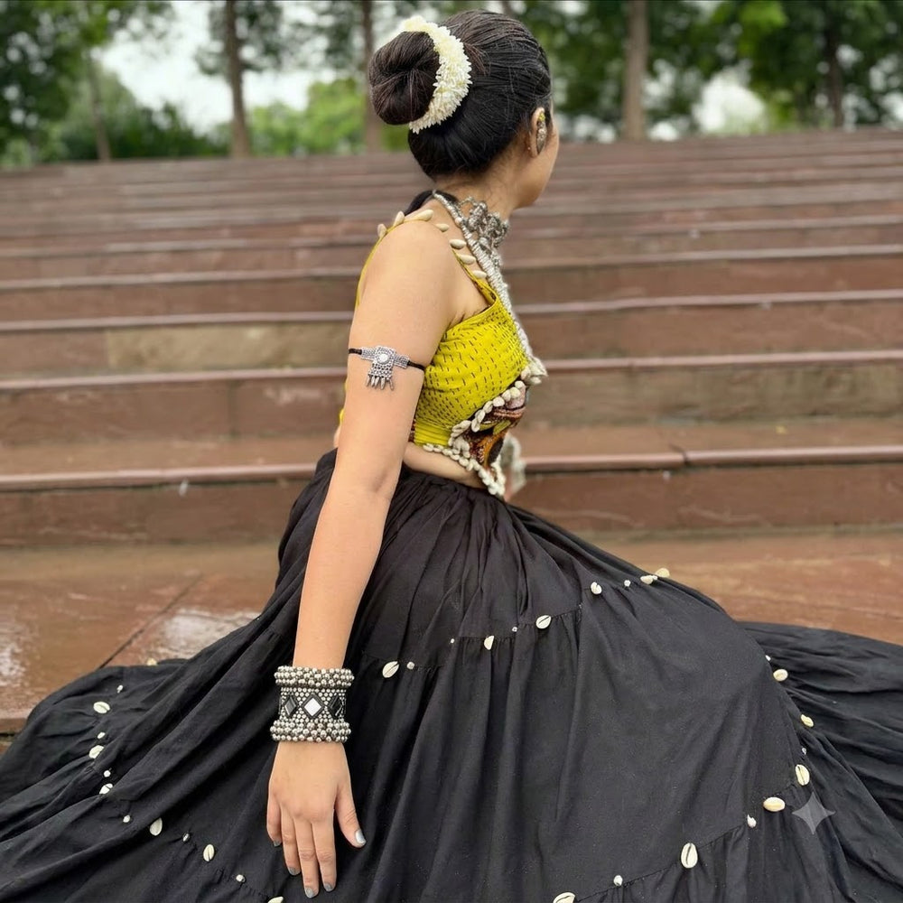 Indian model in Navratri chaniya choli wearing oxidized silver mirror work ghungroo cuff on raised wrist, Garba event background with fairy lights