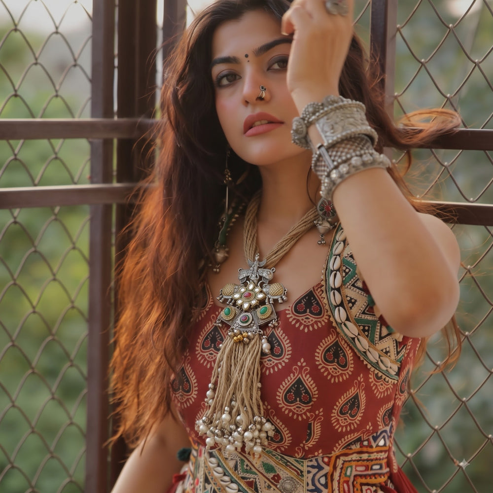 Model styling the long elephant pendant necklace with a fusion outfit