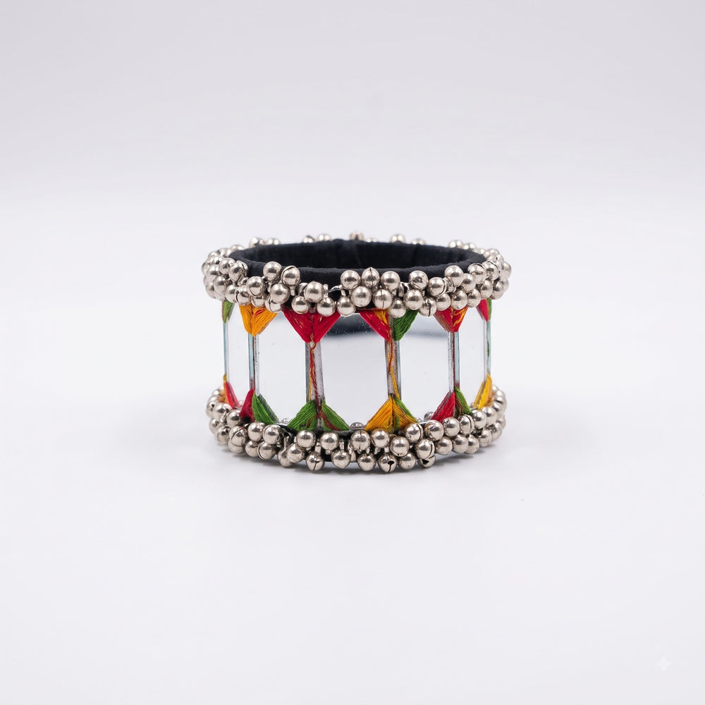 Large mirror tile ghungroo cuff bracelet on white background, three-quarter angle showing open-back cuff construction, large mirror panels and dense silver ghungroo rows on top and bottom edges