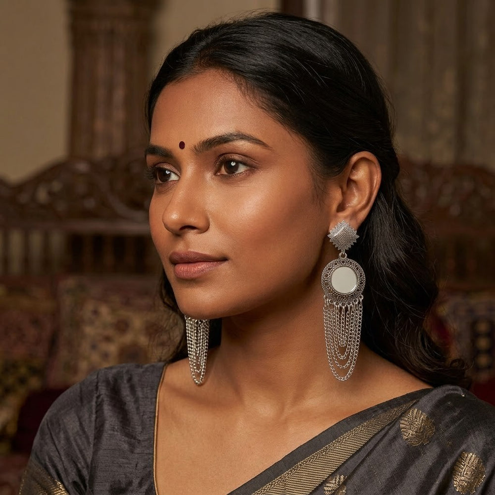 Indian model wearing oxidized silver sun star mirror chandelier earrings with silver turtleneck, front-facing portrait