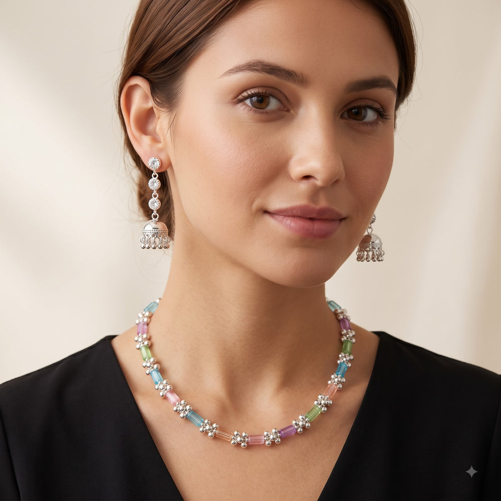 Model wearing pastel stone necklace with silver-tone jhumka earrings